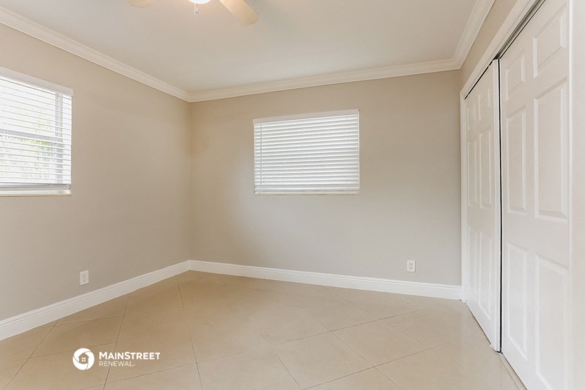 an empty room with a white door and a window
