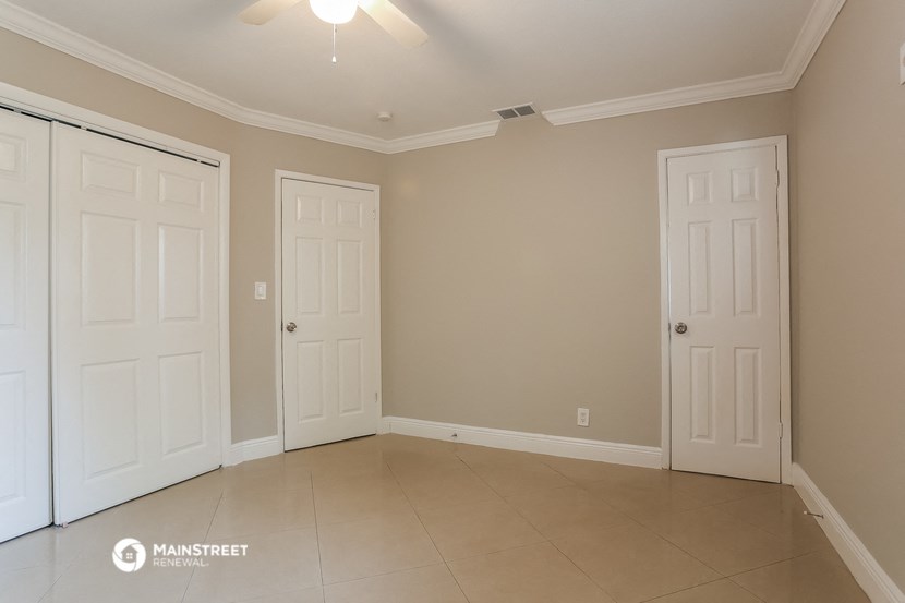 a empty room with two doors and a tiled floor