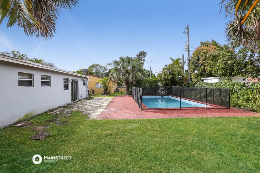 a backyard with a pool and a fence and a house