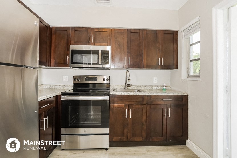 a kitchen with wooden cabinets and stainless steel appliances