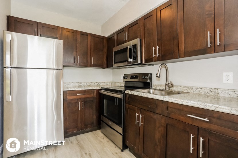 a kitchen with wooden cabinets and stainless steel appliances