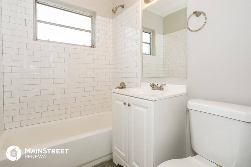 a white bathroom with a toilet and a sink