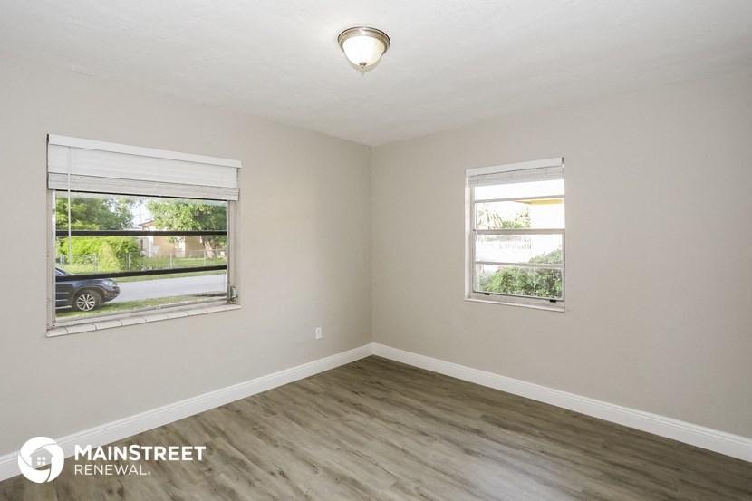 the living room of an empty house with two windows