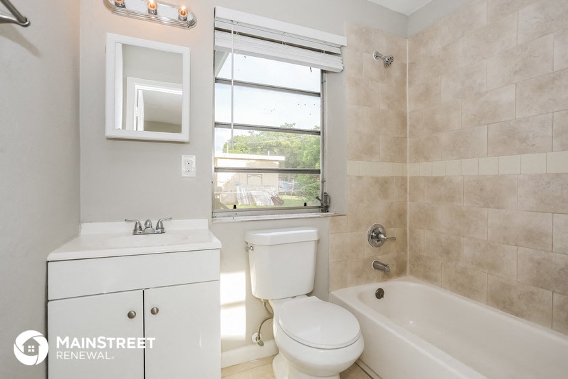 a bathroom with a tub and a toilet and a window
