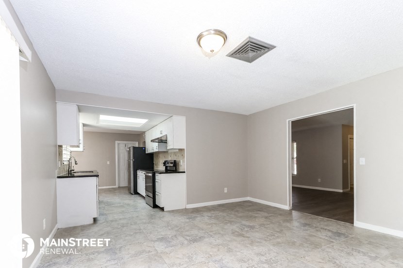 the living room and kitchen of an empty apartment