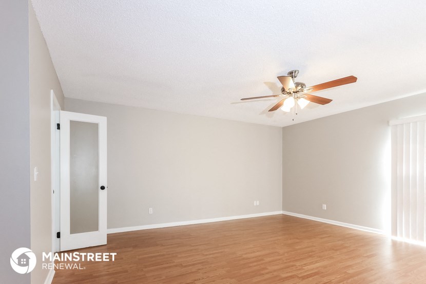 the living room of an empty house with a ceiling fan