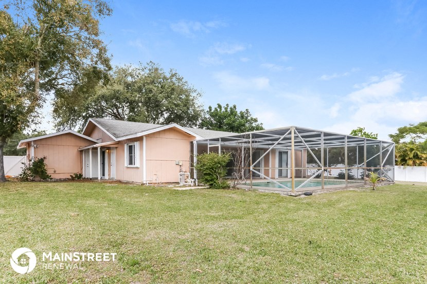 a house with a greenhouse in front of a yard