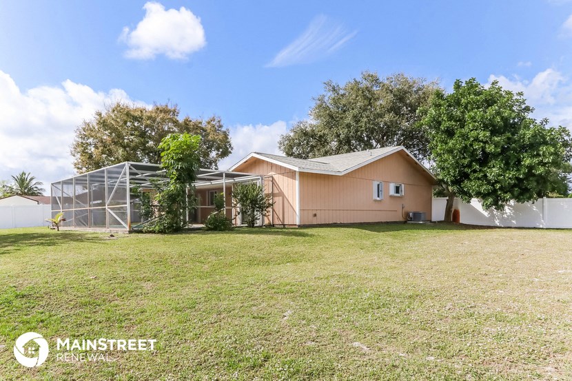 a backyard with a house and a greenhouse