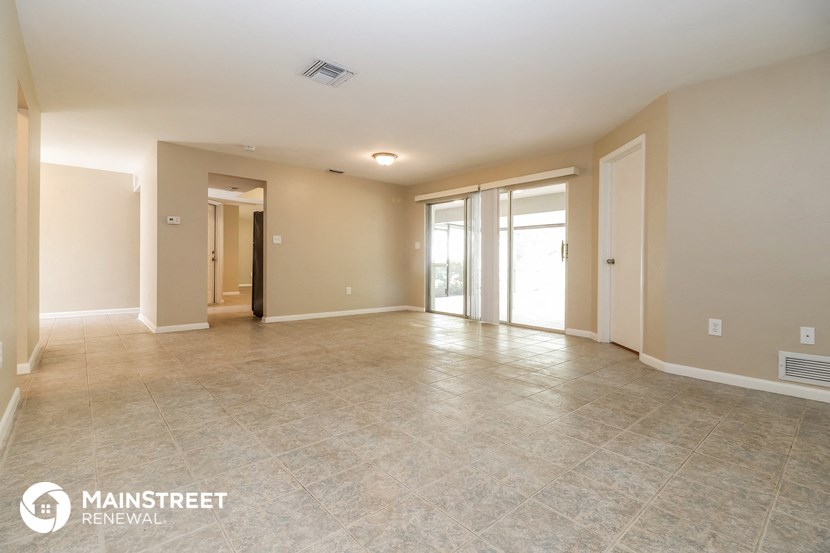the spacious living room is open to the dining room and kitchen