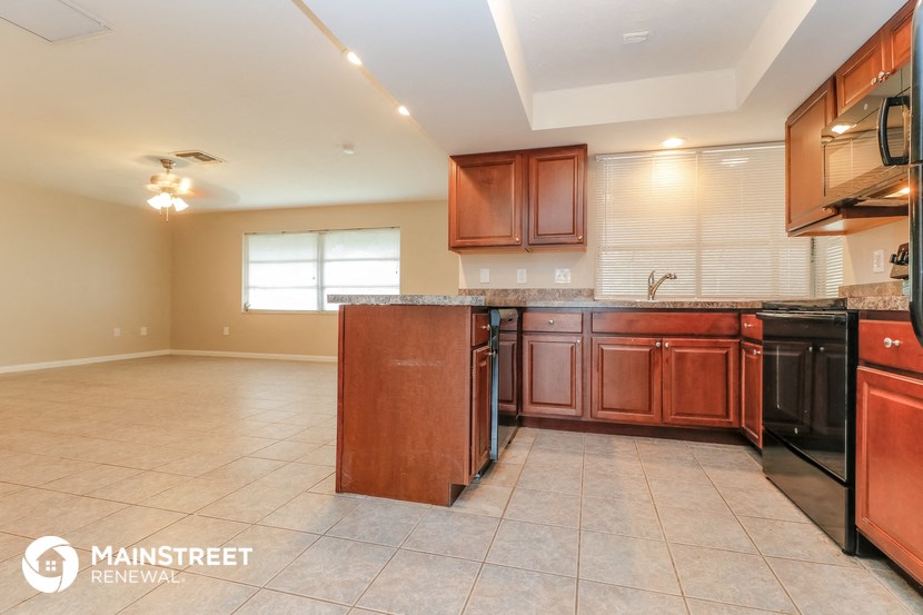 a kitchen with wood cabinets and black appliances and a counter top