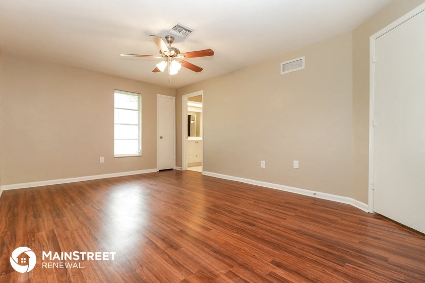 the living room with hardwood flooring and a ceiling fan