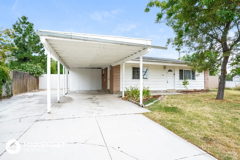 a white house with a covered porch and a driveway