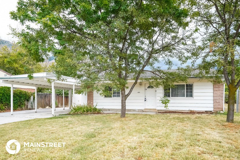a small white house with trees in front of it