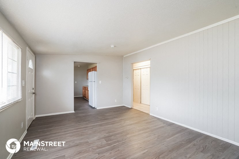 a living room with white walls and wood flooring