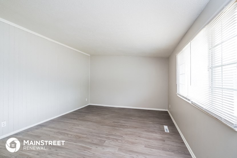an empty room with wood floors and white walls