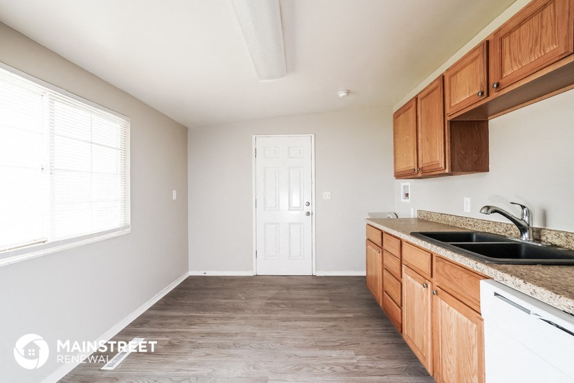 an empty kitchen with wooden cabinets and a sink
