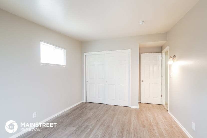 the living room of a new home with white walls and wood flooring