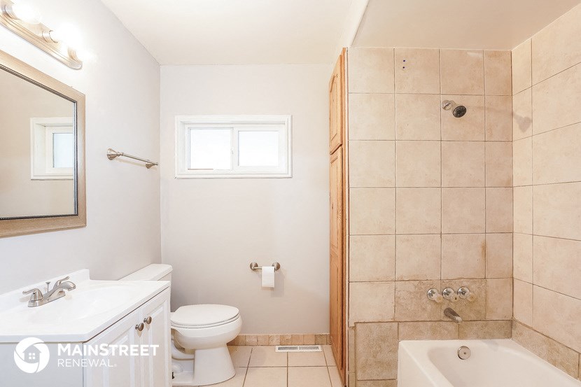 a white bathroom with a shower toilet and sink