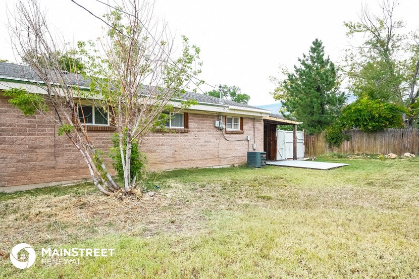 a small brick house with a yard and a tree