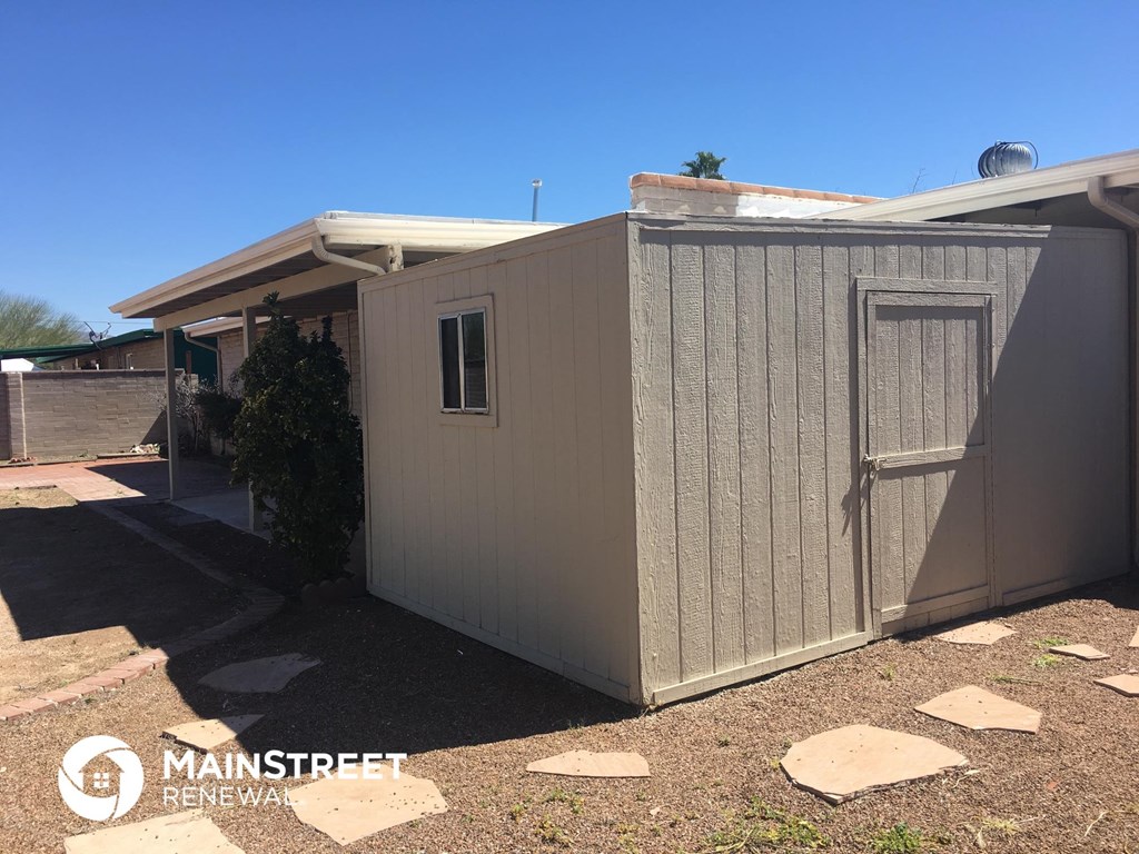a small shed with a door on the side of a house