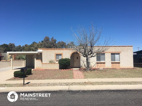 a small brick house on the side of a street