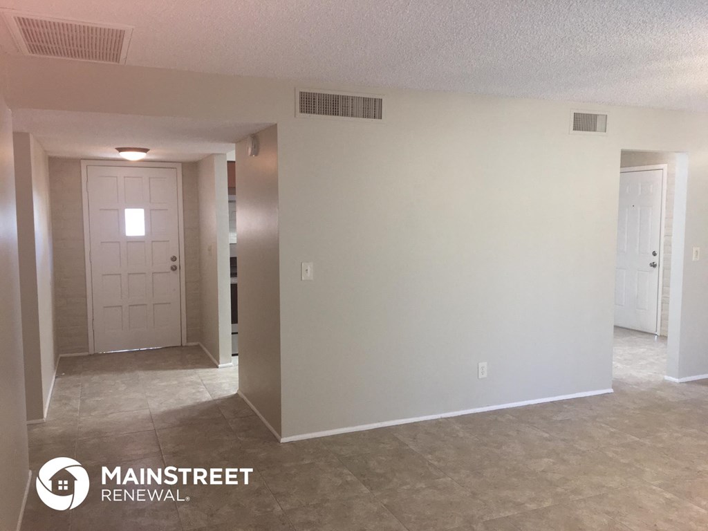 the living room of an empty renovated house with white walls and a white door