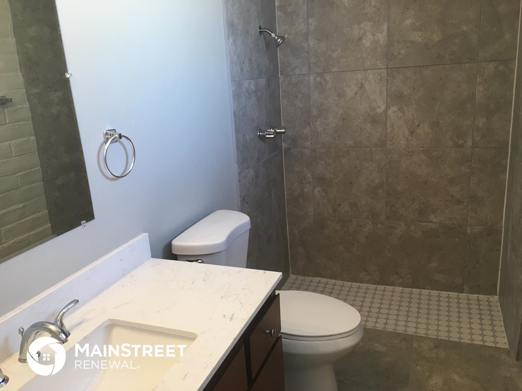 a small bathroom with a shower toilet and sink