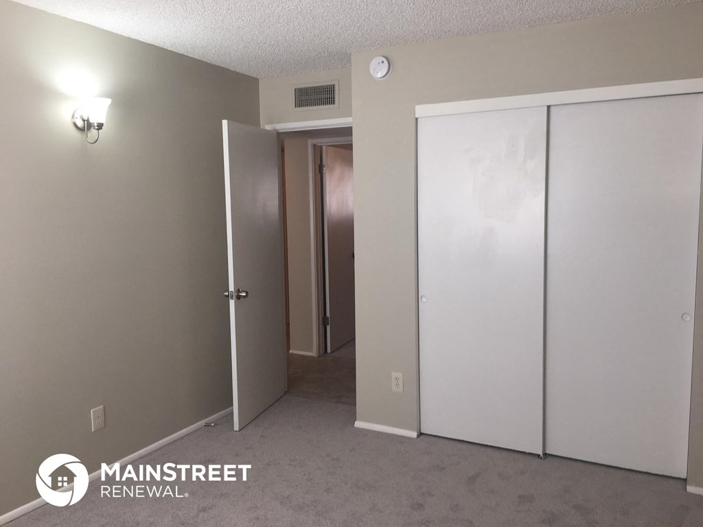 a bedroom with two closets and a hallway with a door to a closet