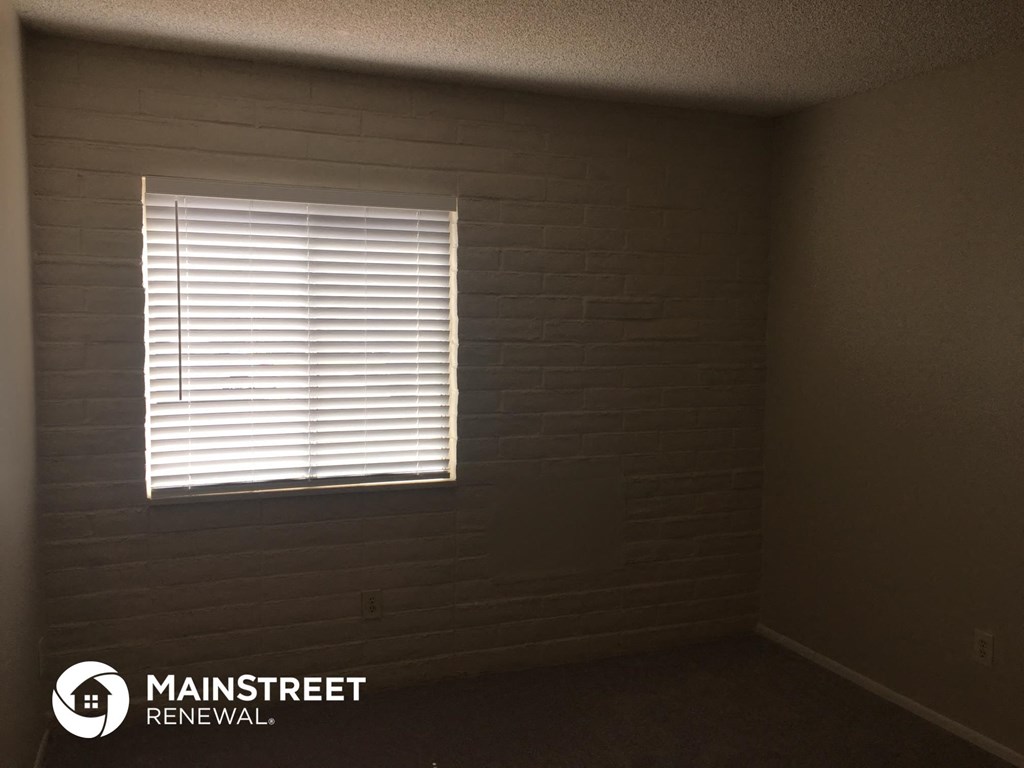 a room with a window with blinds on it