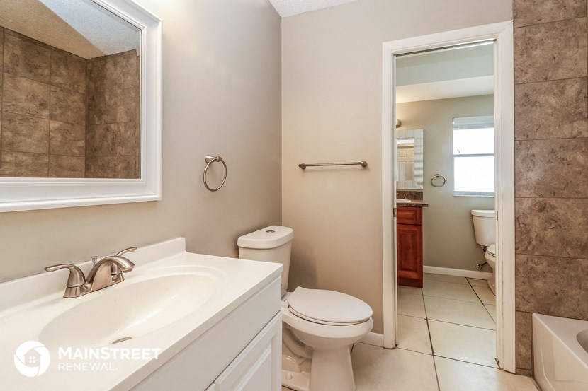 a bathroom with a toilet and a sink and a mirror