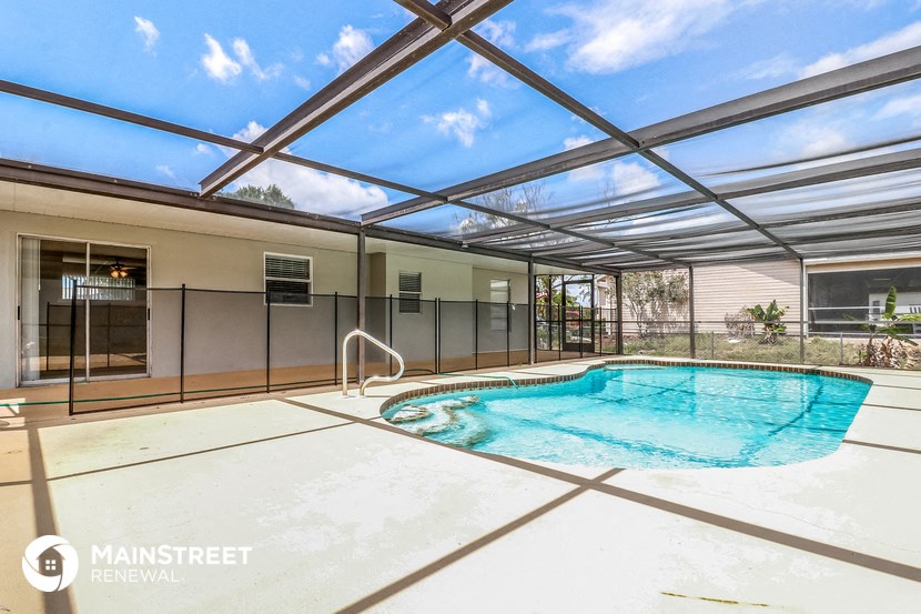 a swimming pool is under a glass roof and next to a glass pool