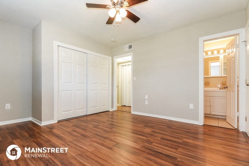 the living room and dining room with wood flooring and a ceiling fan