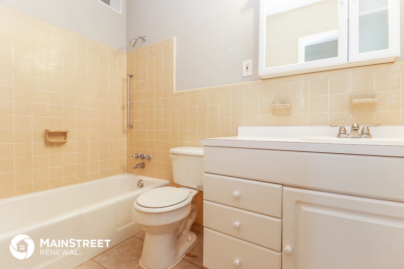 a bathroom with a toilet and a sink and a bath tub