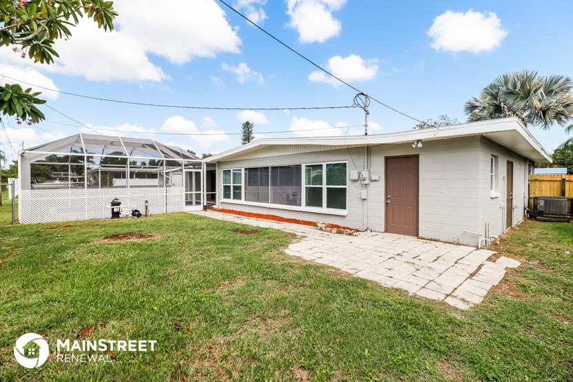 a small white house with a yard and a porch