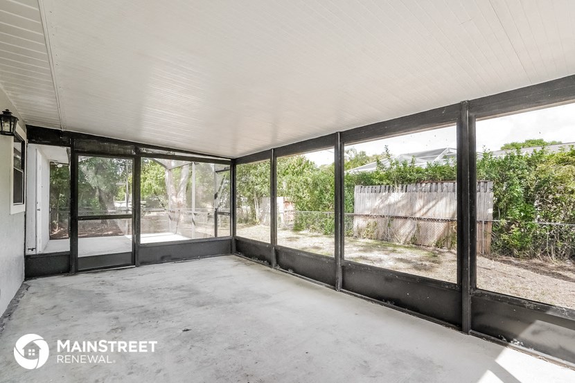 a room with large windows and a concrete floor and a fence