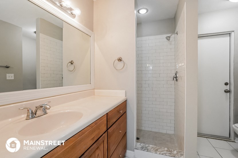 a bathroom with a sink and a mirror and a shower