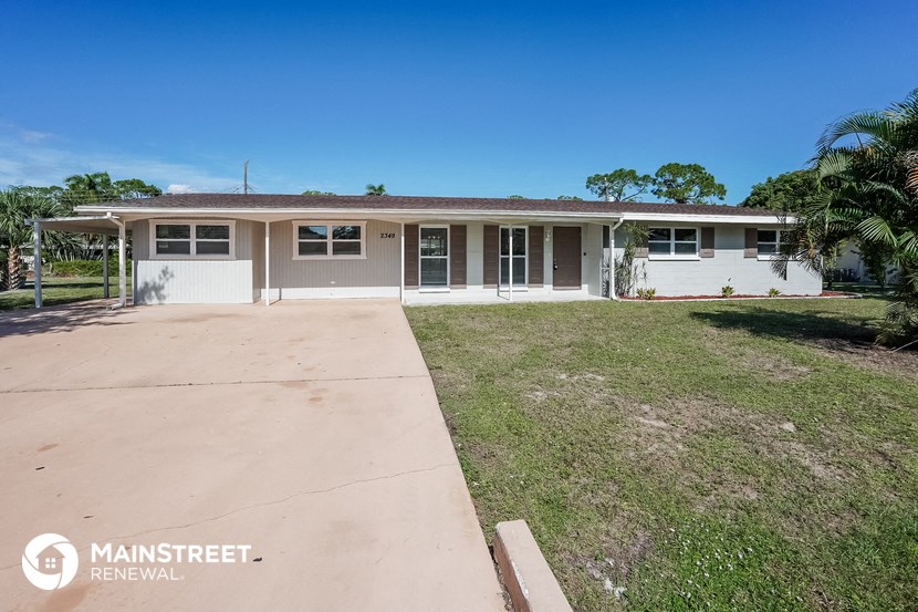a house with a driveway and a lawn in front of it