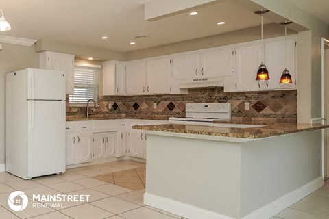 a white kitchen with white cabinets and a counter top