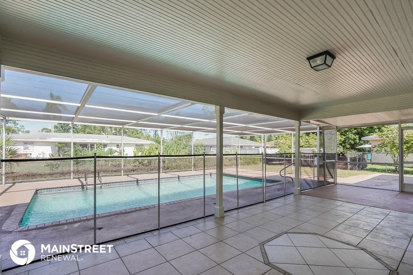 a large swimming pool in a house with glass doors