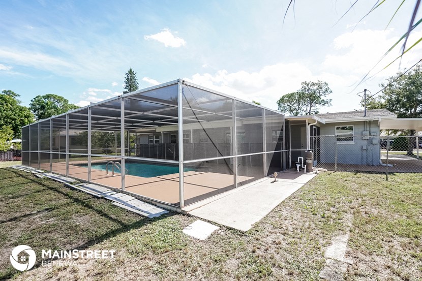 a pool in a glass enclosure in front of a house