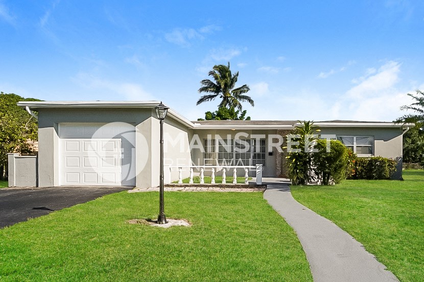 a house with a porch and a palm tree