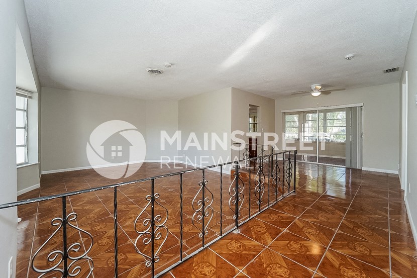a large living room with a large window and a balcony