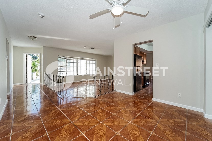 a sweeping staircase leads to the living room and dining room