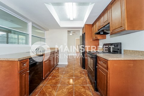 a renovated kitchen with marble counter tops and wooden cabinets