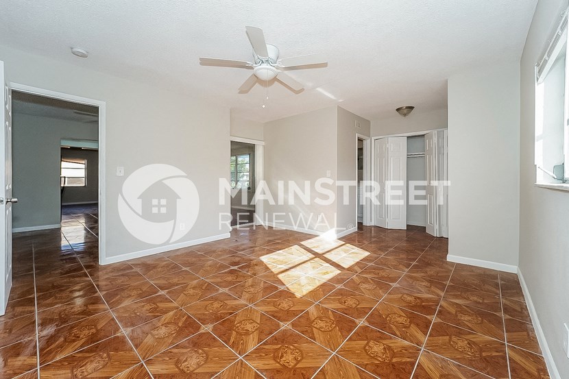 a renovated living room with tile flooring and a ceiling fan