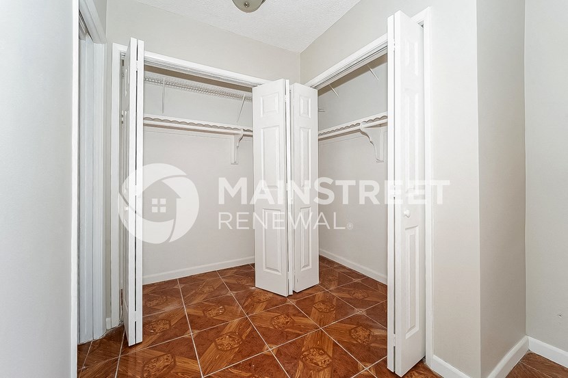 a walk in closet in a master bedroom