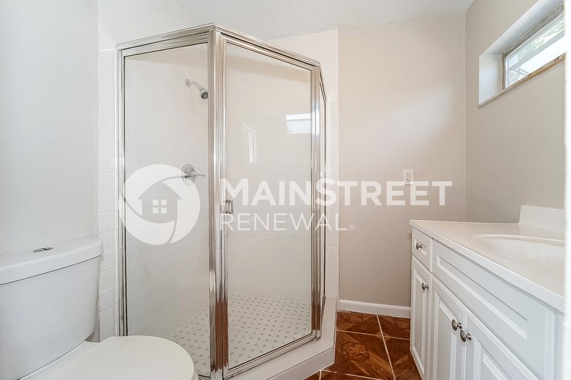 a bathroom with a shower and a sink and a toilet