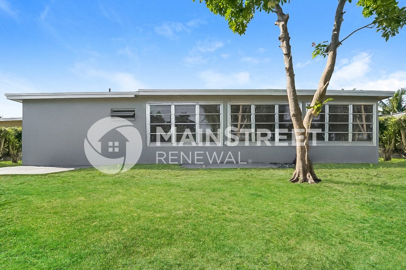 a house with a tree and a lawn in front of it
