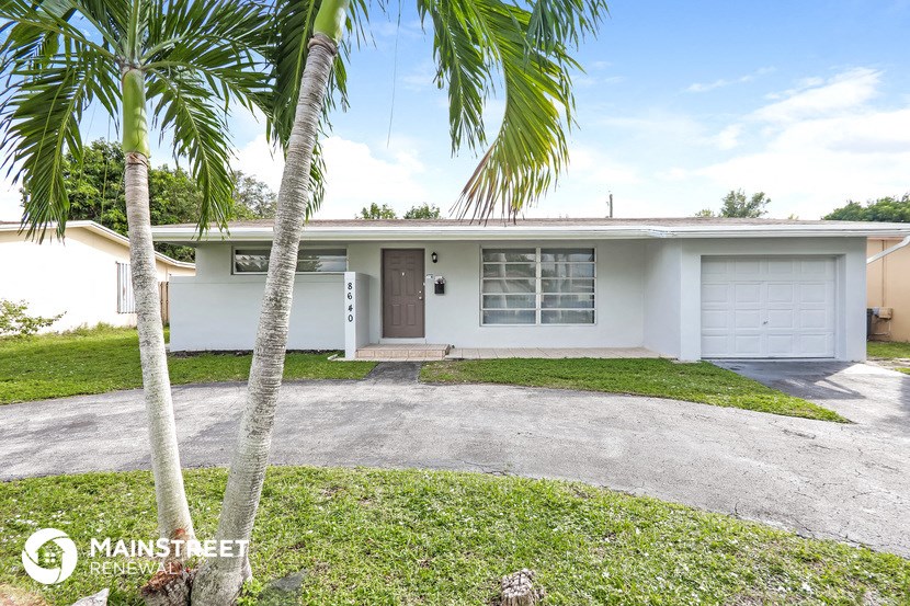 a home with palm trees in front of it