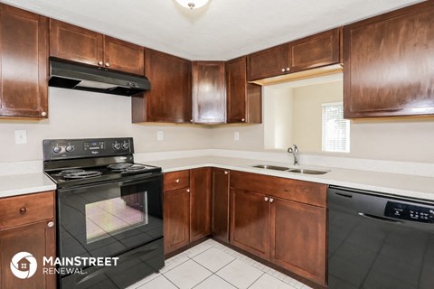 a kitchen with wooden cabinets and black appliances and a black stove top oven
